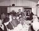 Stan at microphone speaking at the 1949 family reunion in the dining room of the homestead.